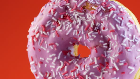 Closeup fresh appetizing donut sweet in a plate rotates on a bright orange background