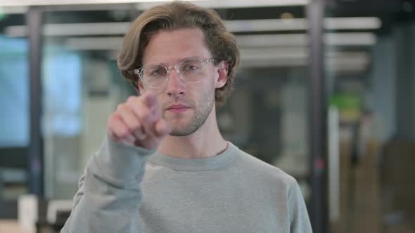 Portrait of Young Businessman Pointing at Camera