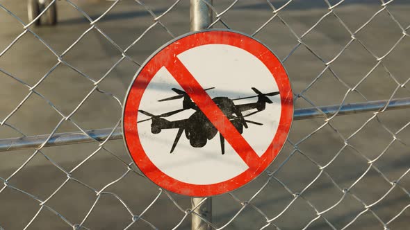 Uprising view at a sign of area prohibited for drones. Airport. Fence. 4k HD