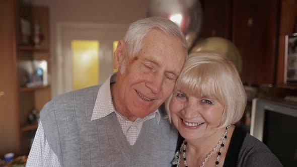 Portrait of a Happy Grandfather and Grandmother Who Smiling Looks at Camera