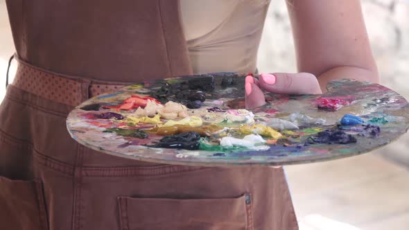 Palette with Different Colors of Oil Paint in Hand Artist