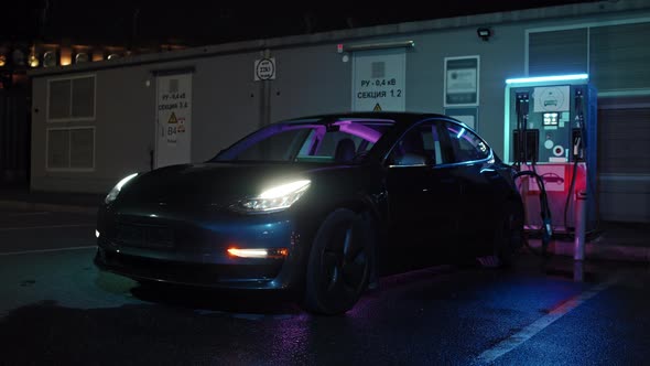 Charging Electric Car at EV Station at Night