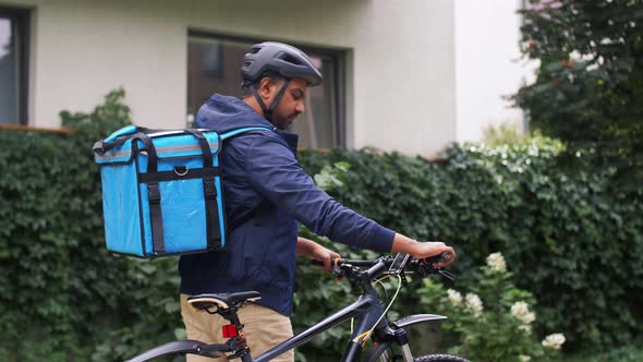 Indian Delivery Man with Bag and Bicycle in City