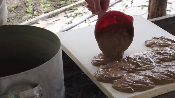 Caucasian Male Potter Prepares Liquid Clay for Modeling Pours It Onto a Board for Drying