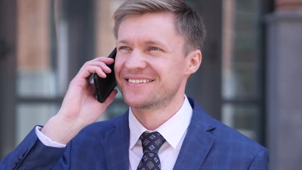 Businessman Talking on Phone Discussing