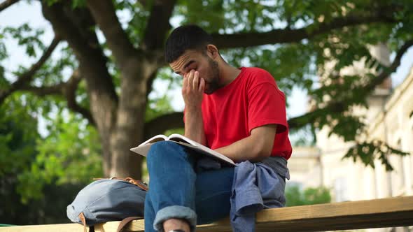 Portrait of Focused Middle Eastern Student Rubbing Eyes and Temples Memorizing Academic Material