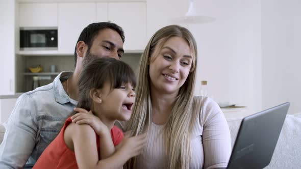 Happy Parents Couple with Excited Little Daughter