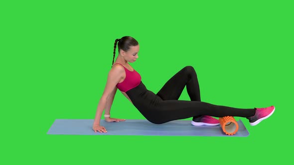 Girl Doing Exercise for Calf Muscle with a Foam Roller on a Green Screen Chroma Key