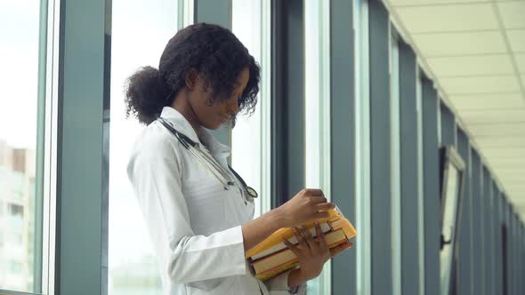 African American Woman Student Intern with a Books in the Hospital. New Modern Fully Functional