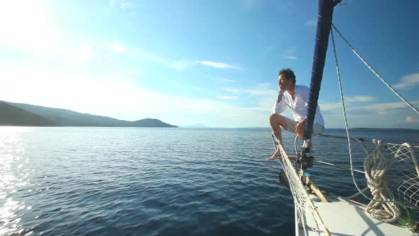 Man on the bow of sailing boat on Mediterranean sea.