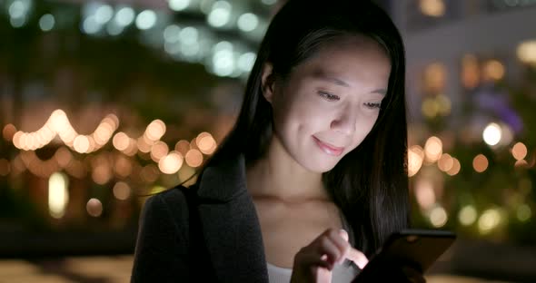 Woman use of smart phone at outdoor in the evening