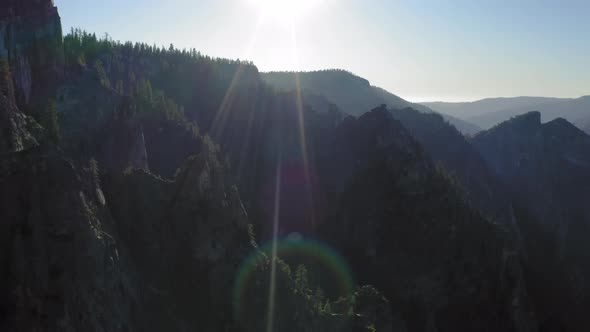 Scenic Aerial Survey Over the Yosemite National Park Lit with Bright Sunset Rays.