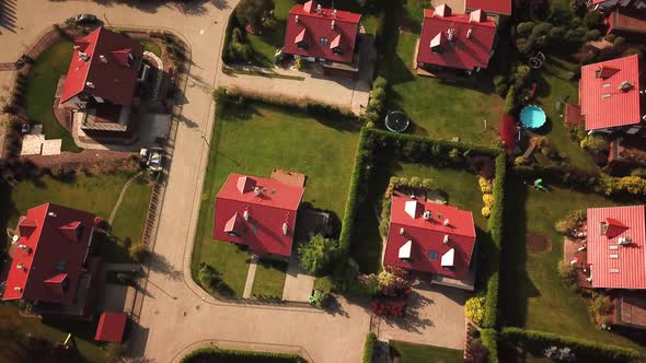 Overhead right pan across houses, yards and cars along suburban street. Aerial shot 4k