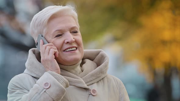 Closeup Elderly Lady Speak on Smartphone Shares News Grandma Enjoying Using Device Outdoors Positive