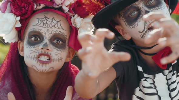 Boy and Girl in Halloween Costumes Acting Scary