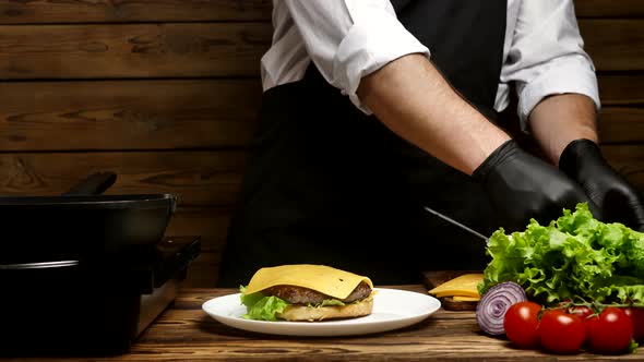 Closeup of the Chef's Hands Preparing an Appetizing Hamburger