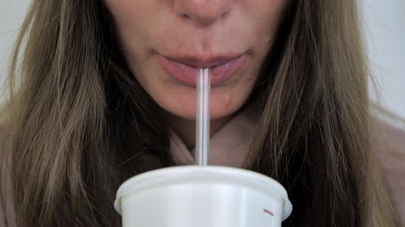 Closeup of the Woman s Lips Drinking a Beverage From a Tube
