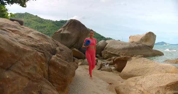 Millennial Woman Walking on the Beach for Morning Exercise She Walks Between the Rocks to the Spot