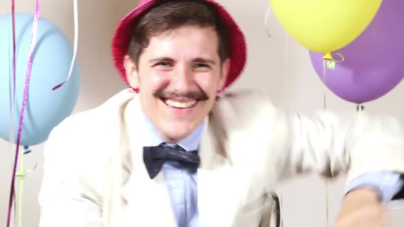 Close up of happy man with pink hat dancing in photo booth