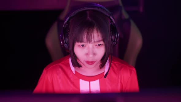 Handheld Portrait of a Asian Female Gamer in Headphones Plays a Video Game Cyber Sportsman at the