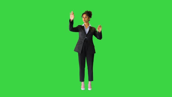 Young Black Lady Looking at a Virtual Screen on a Green Screen Chroma Key