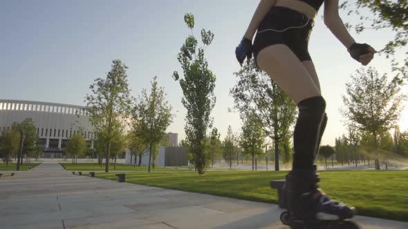 Beautiful Young Woman On Rollerblading In Park At Sunrise