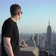 Man on Rooftop in New York Looks at Skyscrapers and Buildings of Manhattan - VideoHive Item for Sale