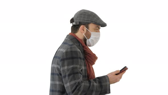 Adult Man Wears Protective Medical Mask Talking on the Phone and Walking on White Background