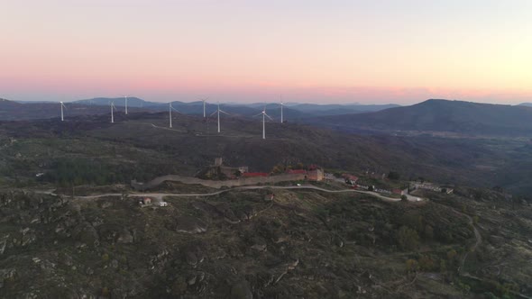 Drone aerial panorama of historic village of Sortelha with castle and with turbines on natural lands