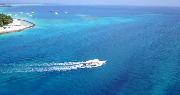 Beautiful fly over travel shot of a paradise sunny white sand beach and blue water background in bes