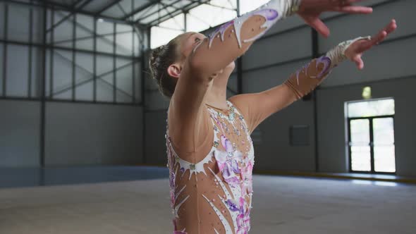 Teenage female gymnast performing at sports hall