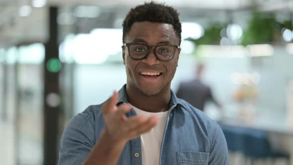 Portrait of Young African Man Pointing at the Camera and Inviting