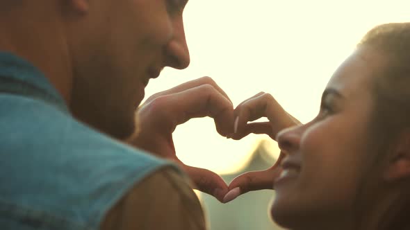 Couple Making Heart Symbol with Hands