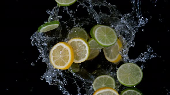 Super Slow Motion Shot of Rotating Exploded Lemon and Lime Slices with Splashing Water at 1000Fps