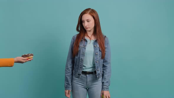 Close Up of an Young Woman Who Refuses a Donuts Showing That She Has an Apple