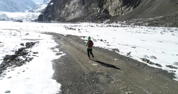 Woman trail runner cross country running in winter nature, Aerial view drone footage, slow motion