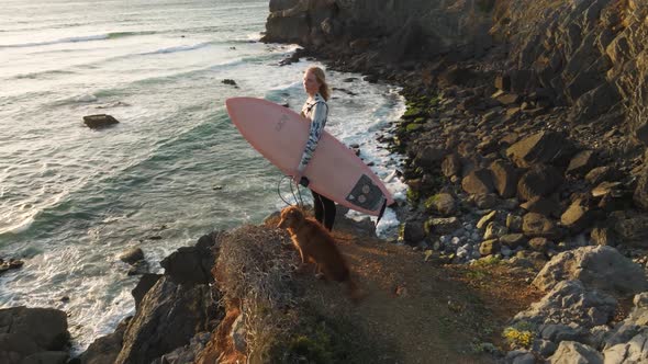 4k drone close up Slow motion Surfer with board. Slim woman in swimsuit looking at the beach on the