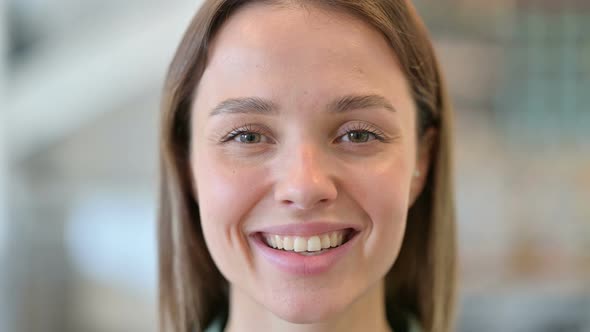 Close Up of Face of Happy Young Woman Smiling at Camera 