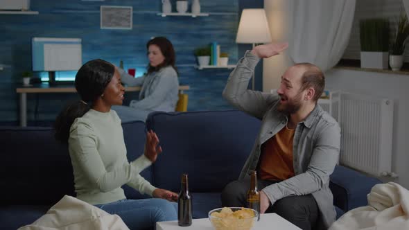 Multiethnic Friends Relaxing on Couch While Giving High Five Laughing and Having Fun