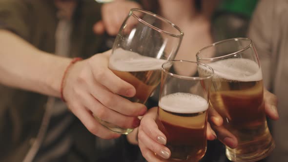 Friends Toasting Beer Mugs At Bar