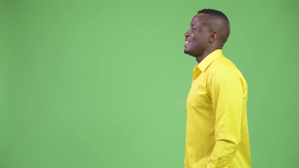 Profile View of Young Happy African Businessman Wearing Yellow Shirt