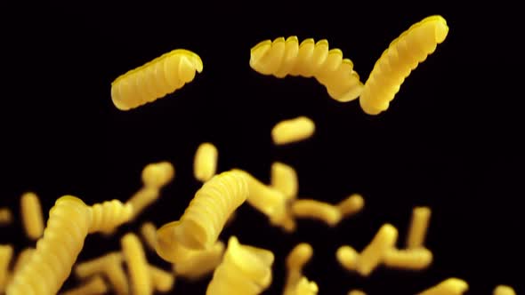 Pasta Fusilli Flying in the Air on Black Background