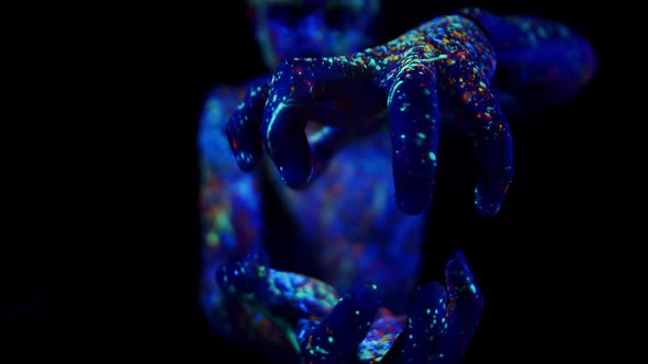 Young Man Painted with Fluorescent Paints Makes Movements with Hands As Holding an Energy Ball Front