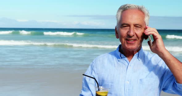 Senior man talking on mobile phone on the phone at the beach