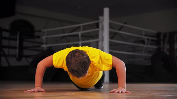 A Little Boy Trying Doing Push Ups Near the Boxing Ring