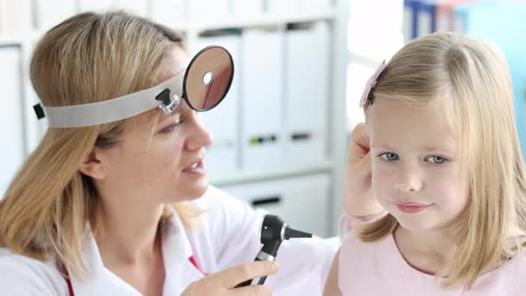 ENT Woman Looks at Ear of Little Girl with Otoscope Slow Motion  Movie