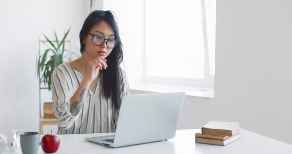 Young Mother Freelancer with Her Child Working at Home Office Using Laptop