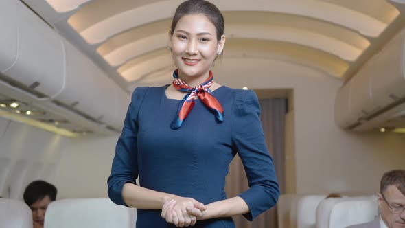 Beautiful flight attendant standing waiting for the passengers to board inside the plane in airport