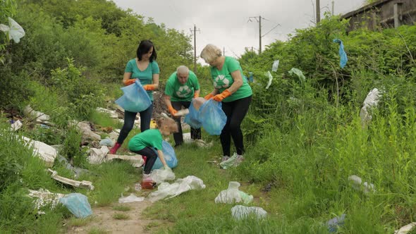 Team of Nature Activists in Eco T-shirts Picking Up Plastic Trash in Park. Recycle, Earth Pollution