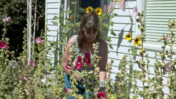 Older woman in her flower garden looking up and smiling